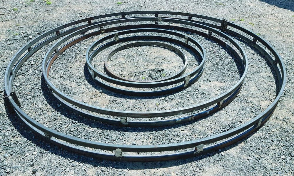 טבעות מתכת מעורגלות של E-DRUM מונחות על הקרקע בסדנה
