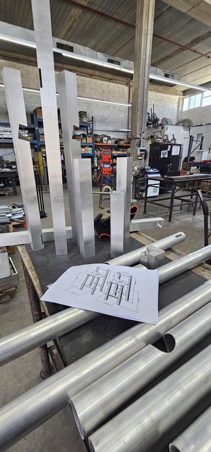 פרופילי מתכת חתוכים והשרטוט של HBS 01 על שולחן העבודה